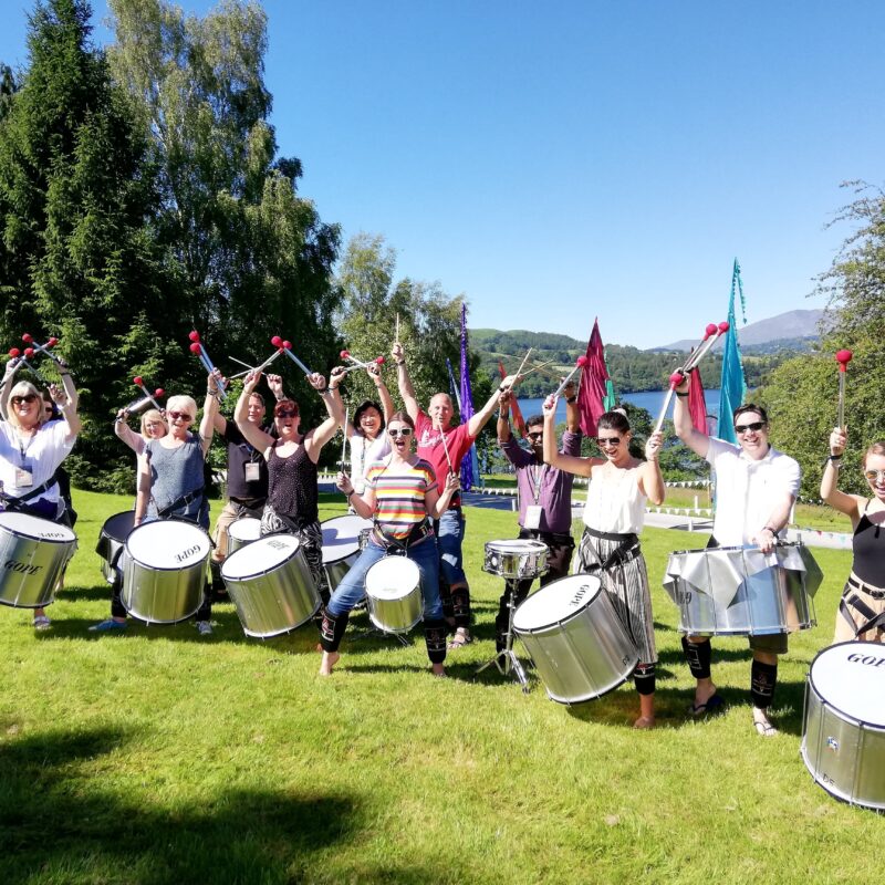 Group of drummers team building and holding drumsticks in the air